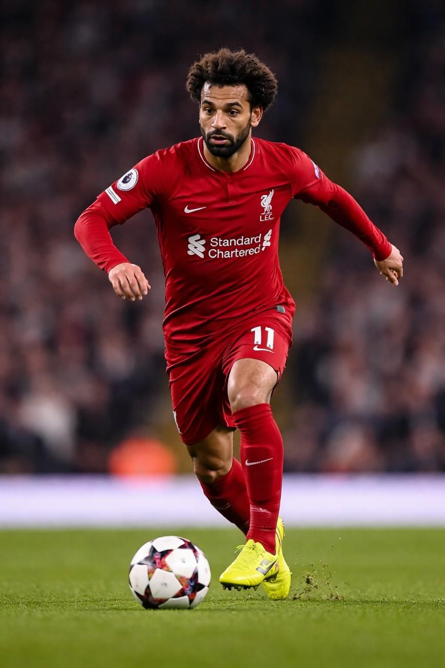 Mohamed Salah playing football on the pitch, showcasing his skills and energy, related to Mohamed Salah net worth 2026