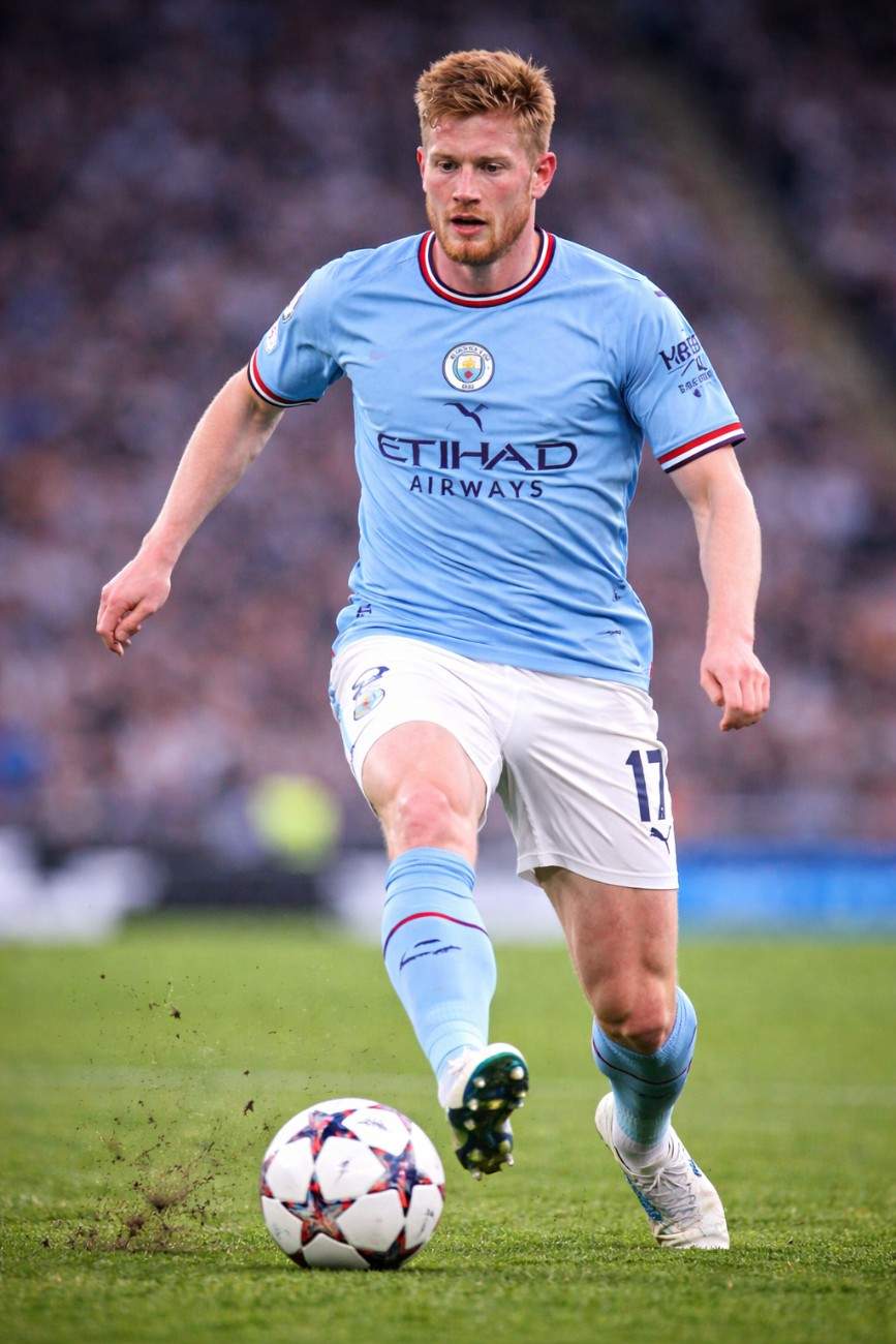 Kevin De Bruyne dribbling the ball during a live football match on the pitch